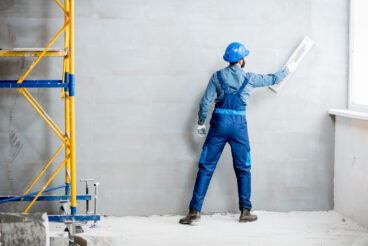 Plasterer,In,Blue,Working,Uniform,Plastering,The,Wall,Indoors