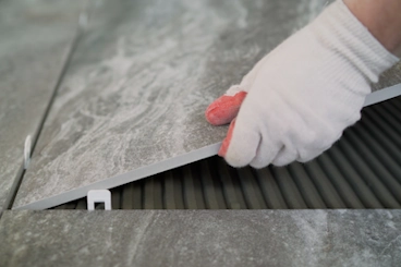 a worker puts a large tile on the floor